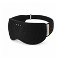 A black sleep mask with a breathable mesh front panel, adjustable black strap, and a small beige brand plaque on the side. The front features simple white control symbols.