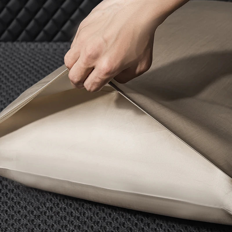 Hand adjusting a beige cushion on a sofa