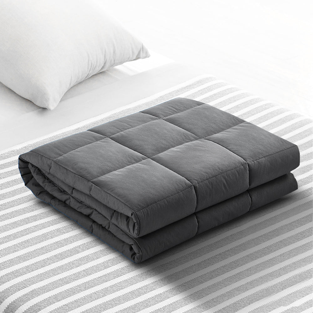 Gray weighted blanket on a bed with striped bedding